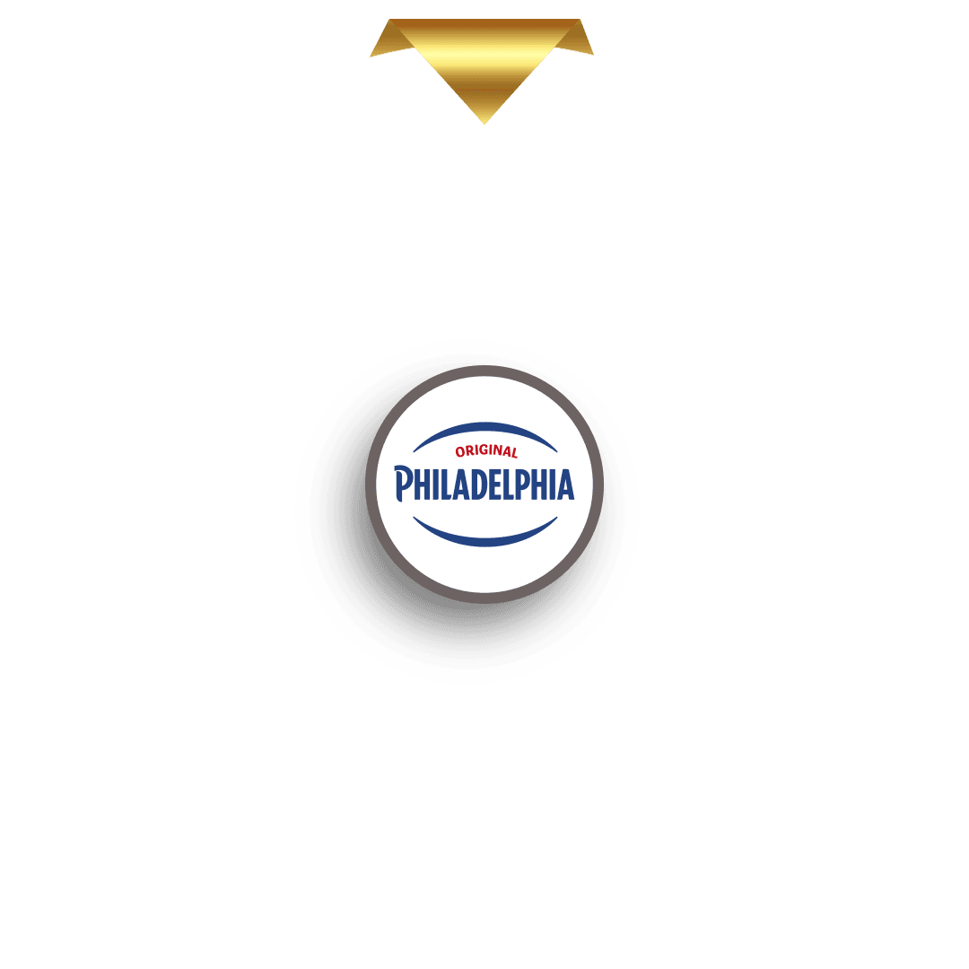 En guldmarkør i form af en nedadgående trekant er placeret over en cirkulær markør med et stiliseret, glitrende guldbogstav "M" i midten. Markøren kaster en skygge og er designet til at flugte med det øverste segment af et præmiehjul (ikke vist på dette billede).